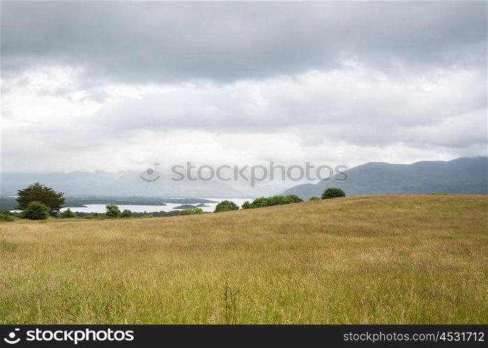 nature and landscape concept - view to plain with lake or river valley and hills at connemara in ireland. view to lake and hills at connemara in ireland