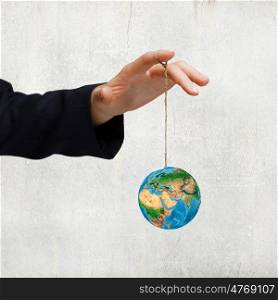 Nature and mankind. Close up of human hand holding Earth planet on rope. Elements of this image are furnished by NASA