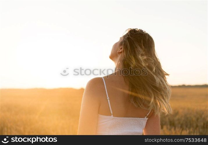 nature and people concept - young woman on cereal field in summer. woman on cereal field in summer