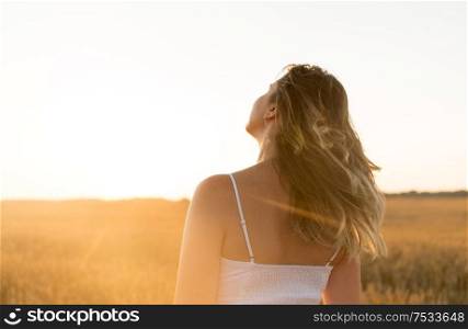 nature and people concept - young woman on cereal field in summer. woman on cereal field in summer