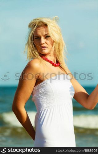 Nature beach outdoors and female. Nice lady enjoying nature and beach. Young woman wearing long white dress and beautiful red necklace. . Nice female enjoying nature and beach.