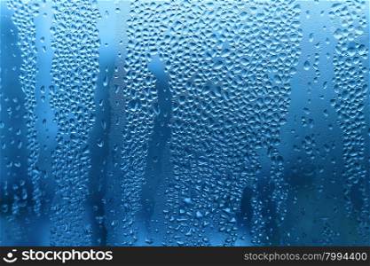 Nature blue background with water drops on glass