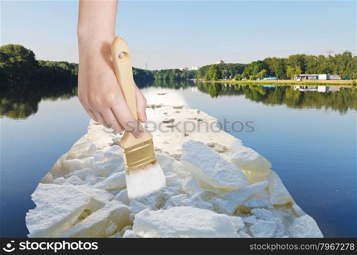 nature concept - seasons and weather changing - hand with paintbrush paints ice blocks in lake in summer
