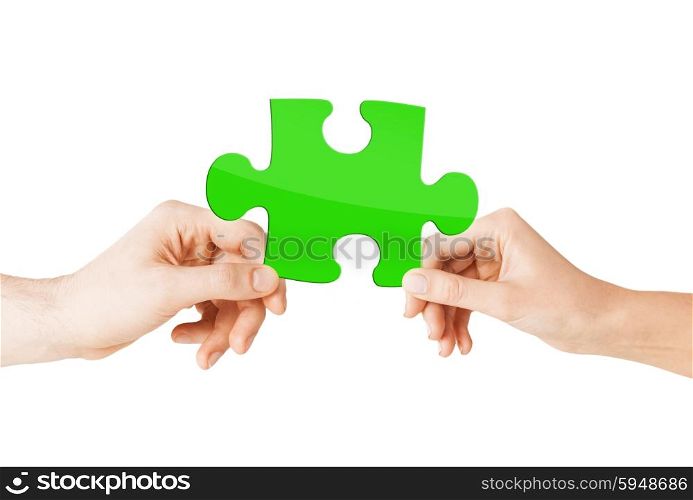 nature, ecology, energy saving and people concept - close up of couple hands with green puzzle
