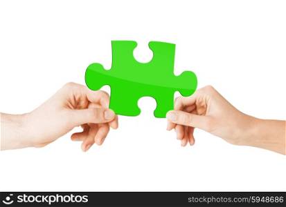 nature, ecology, energy saving and people concept - close up of couple hands with green puzzle