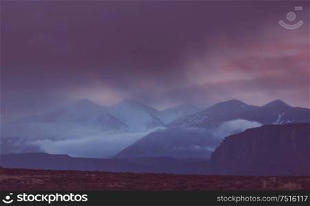 Nature force background - dark stormy sky in snowy mountains