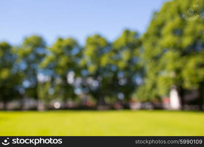 nature, landscape, background and environment concept - blurred summer field, trees and blue sky bokeh