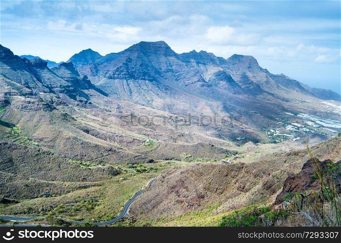 Nature landscape of Canary Island with mountain range, green hills and curvy road