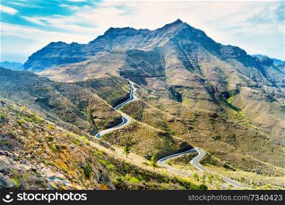 Nature landscape of Canary Island with mountain range, green hills and curvy road