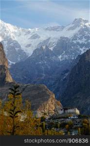 Nature landscape vertical view of Baltit fort and snow capped Karakoram mountain range in the background, Hunza valley. Gilgit Baltistan, Pakistan.