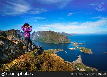 Nature photographer Norway Lofoten archipelago.. Nature photographer tourist with camera shoots while standing on top of the mountain. Beautiful Nature Norway Lofoten archipelago.