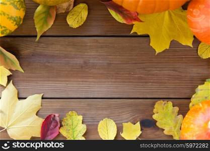 nature, season, advertisement and decor concept - frame of different fallen autumn leaves on wooden board