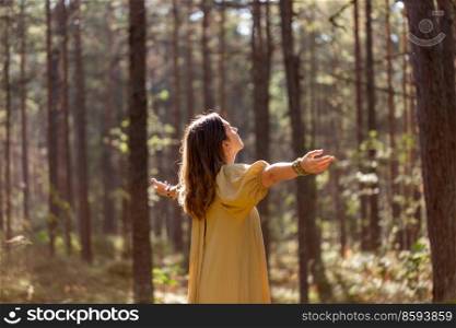 nature, spirituality and supernatural concept - young woman or witch performing magic ritual in forest. woman or witch performing magic ritual in forest