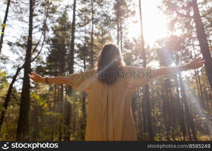 nature, spirituality and supernatural concept - young woman or witch performing magic ritual in forest. woman or witch performing magic ritual in forest