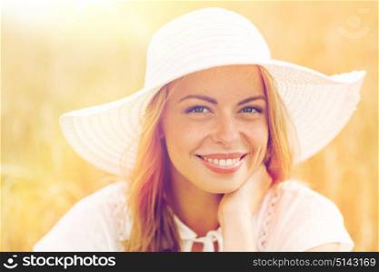 nature, summer holidays, vacation and people concept - close up of happy young woman in white dress and sun hat enjoying sun on cereal field. close up of happy woman in sun hat on cereal field
