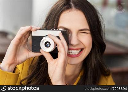 nature, summer holidays, vacation and people concept - close up of happy smiling young woman with film camera outdoors. happy young woman with film camera outdoors