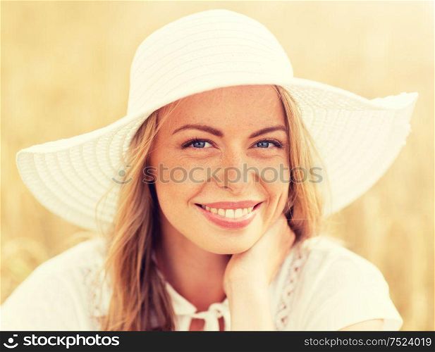 nature, summer holidays, vacation and people concept - close up of happy young woman in white dress and sun hat enjoying sun on cereal field. close up of happy woman in sun hat on cereal field