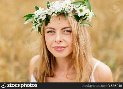 nature, summer holidays, vacation and people concept - face of happy woman in wreath of flowers