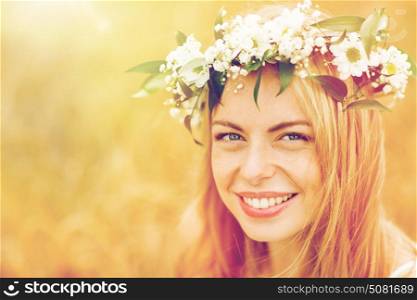 nature, summer holidays, vacation and people concept - face of happy woman in wreath of flowers. happy woman in wreath of flowers
