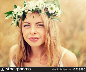 nature, summer holidays, vacation and people concept - face of happy woman in wreath of flowers. happy woman in wreath of flowers