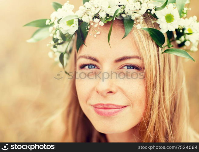 nature, summer holidays, vacation and people concept - face of happy woman in wreath of flowers. happy woman in wreath of flowers