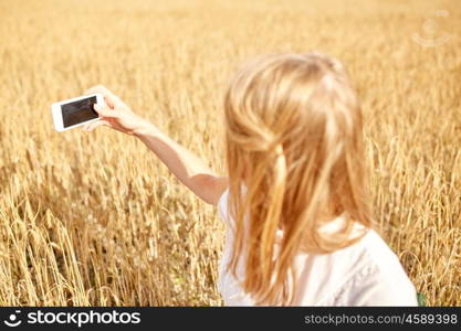 nature, summer vacation, technology and people concept - close up of young woman with smartphone taking picture of cereal field