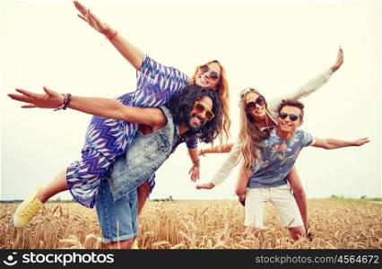 nature, summer, youth culture and people concept - happy young hippie friends having fun on cereal field