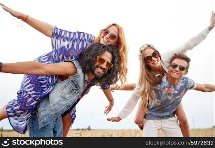 nature, summer, youth culture and people concept - happy young hippie friends having fun on cereal field