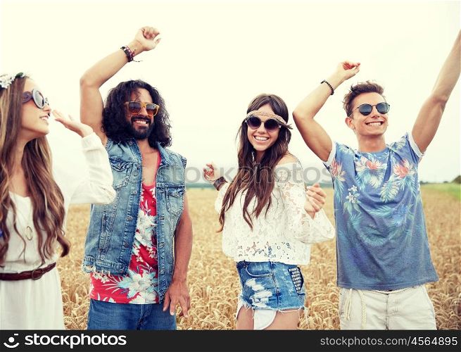 nature, summer, youth culture and people concept - happy young hippie friends dancing outdoors