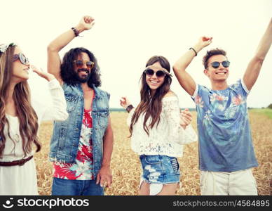 nature, summer, youth culture and people concept - happy young hippie friends dancing outdoors