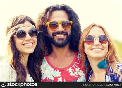 nature, summer, youth culture and people concept - smiling young hippie friends in sunglasses outdoors