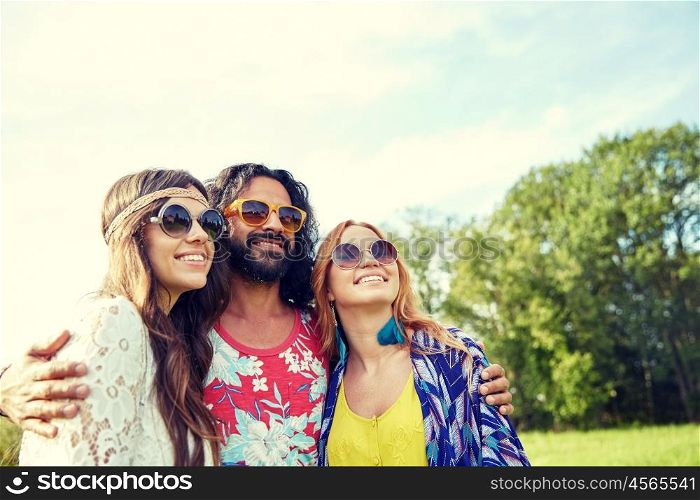 nature, summer, youth culture and people concept - smiling young hippie friends in sunglasses outdoors
