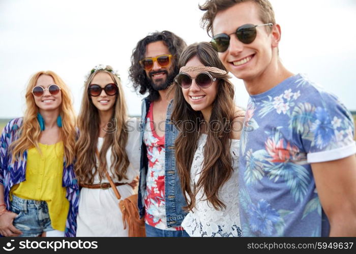 nature, summer, youth culture and people concept - smiling young hippie friends in sunglasses outdoors