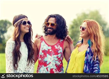 nature, summer, youth culture and people concept - smiling young hippie friends in sunglasses talking outdoors
