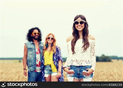nature, summer, youth culture and people concept - smiling young hippie friends on cereal field
