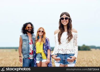 nature, summer, youth culture and people concept - smiling young hippie friends on cereal field