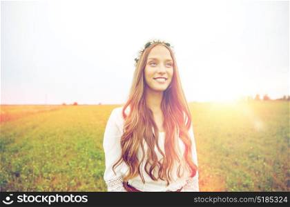 nature, summer, youth culture and people concept - smiling young hippie woman wearing flower wreath on cereal field. smiling young hippie woman on cereal field