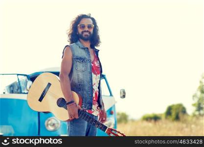 nature, summer, youth culture and people concept - young hippie man playing guitar and singing over minivan car outdoors