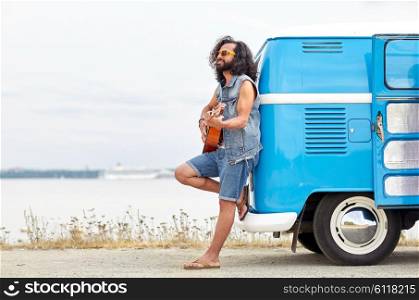 nature, summer, youth culture, music and people concept - young hippie man playing guitar and singing over minivan car on beach