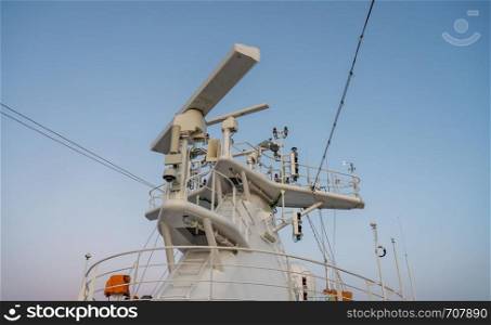 Navigation and radar equipment and antenna on the mast of cruise ship at dawn. Radar antenna on the mast of a cruise ship