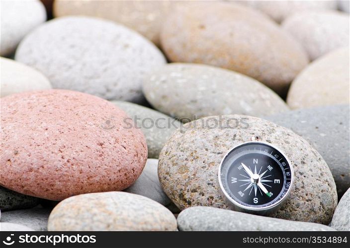 Navigation compass on stone pebbles