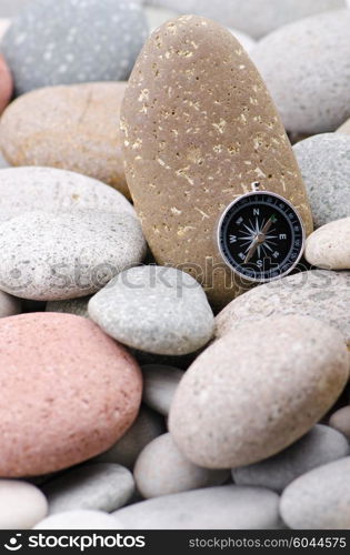 Navigation compass on stone pebbles