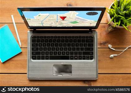 navigation, location, and technology concept - close up of laptop computer with gps navigator map on screen on wooden table