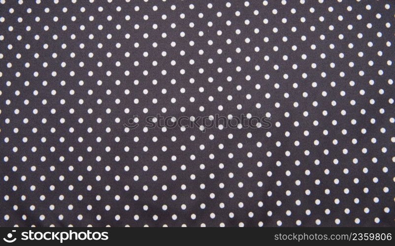 Navy blue fabric with white tiny polka dots. Background texture.