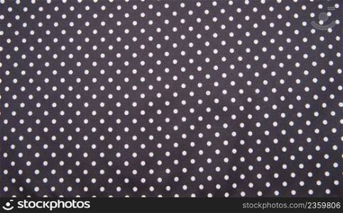 Navy blue fabric with white tiny polka dots. Background texture.