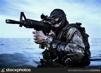 Navy SEAL frogman with complete diving gear and weapons in the water . Navy SEAL frogman