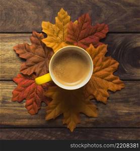 neatly set autumn leaves around coffee mug