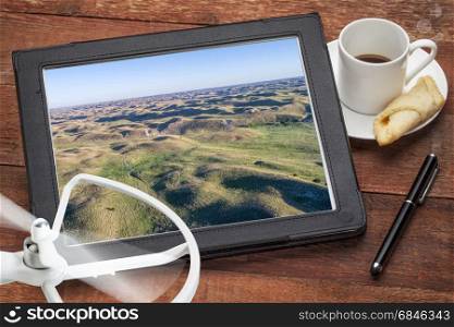 Nebraska Sandhills near Thedford in spring scenery - reviewing aerial picture on a digital tablet with coffee and drone