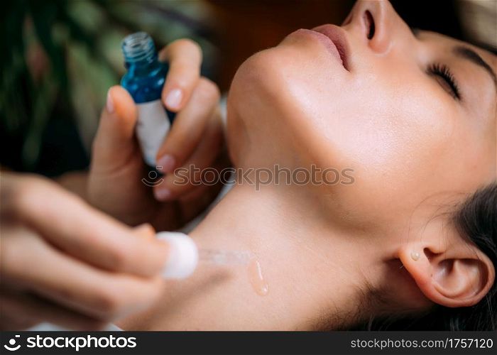 Neck anti-aging treatment. Cosmetician Applying Hyaluronic Acid Serum on Woman&rsquo;s Neck