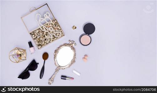 necklace flowers box lipstick blender sunglasses oval comb compact powder lipstick hand mirror purple background